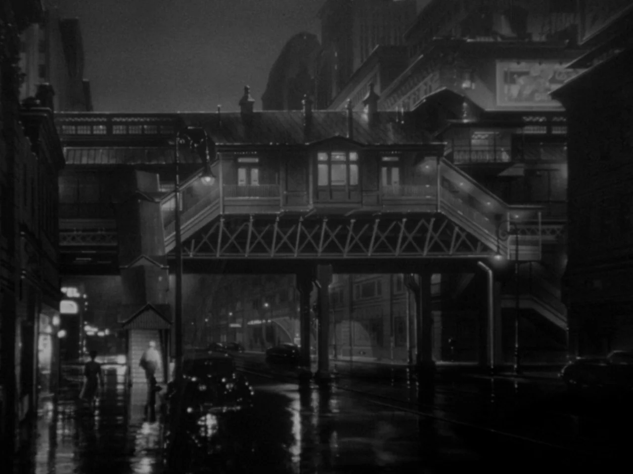 Phantom Lady (1944) movie still: wide — An elevated train structure spans a dark wet street in a city at night. Silhouettes of buildings line the…