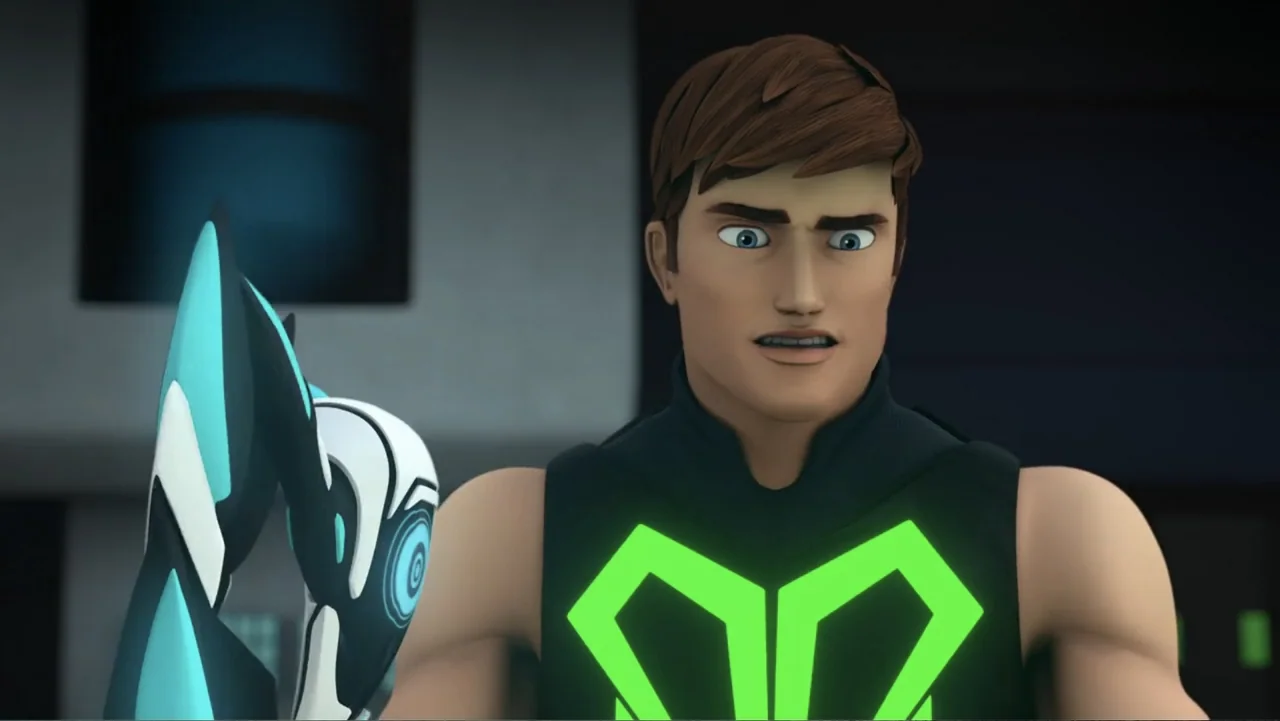 Max Steel: Turbo Warriors (2017) movie still: medium — An interior laboratory setting features dark walls and metallic surfaces in the blurred…