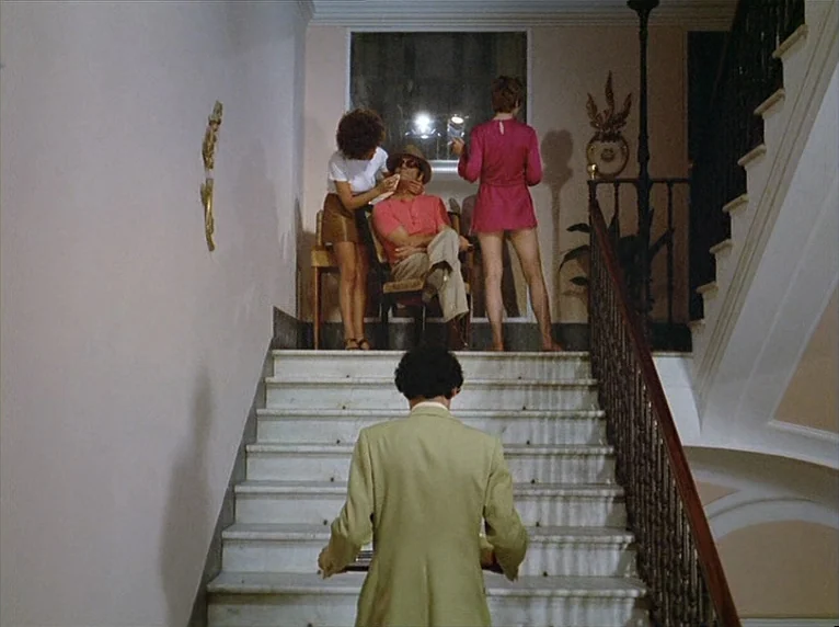 Beware Of A Holy Whore (1971) movie still: wide — A grand marble staircase leads to a landing with a tall window and railings. A man walks up the…