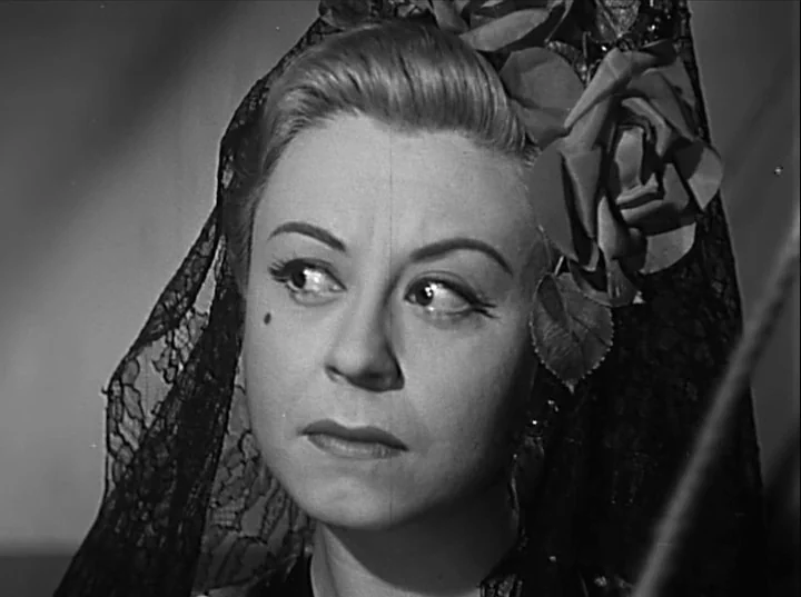 Variety Lights (1950) movie still: closeup — A close-up of a woman in a black lace veil and a floral headpiece. She gazes away from the lens with a…
