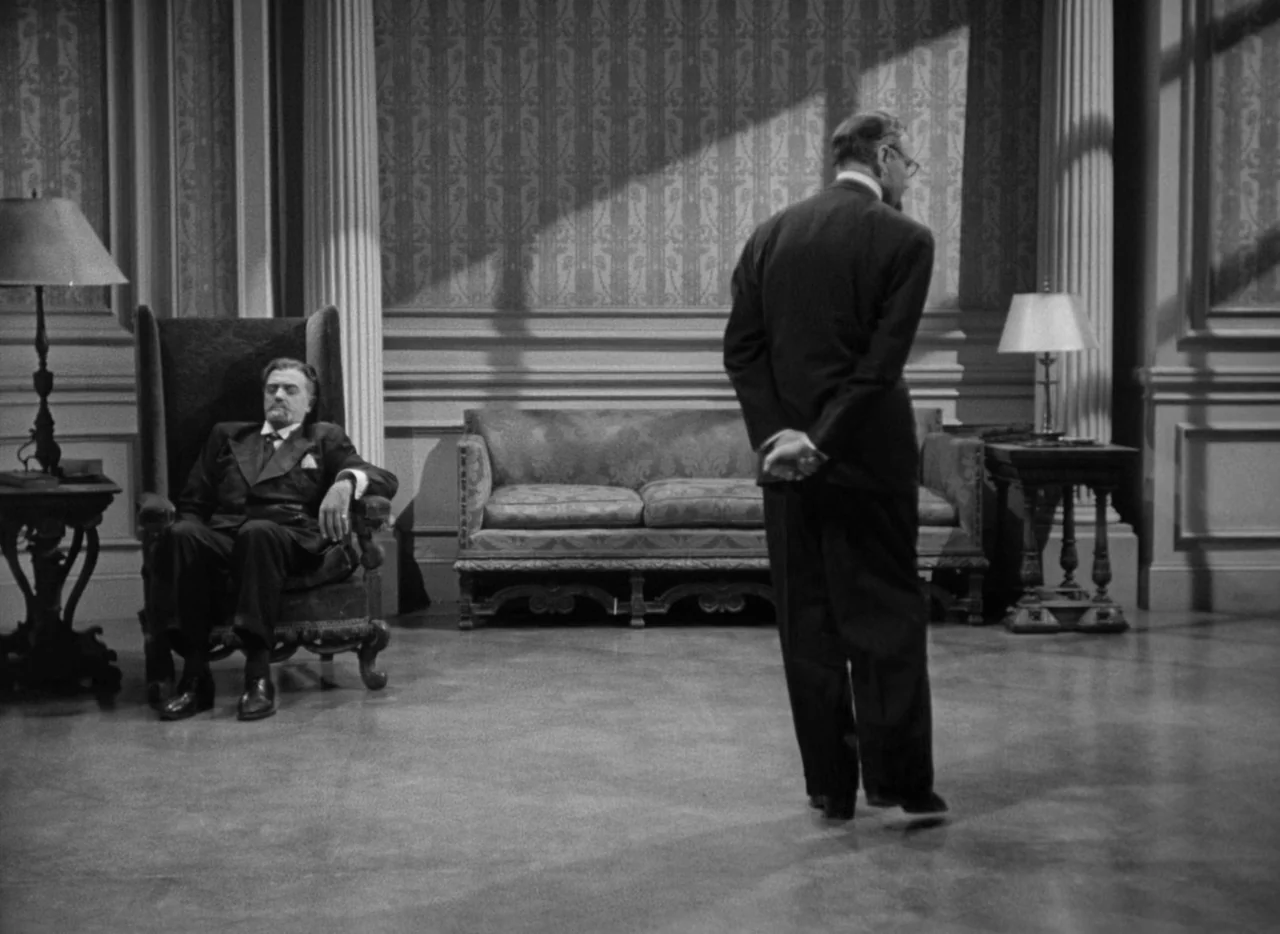 To Be or Not To Be (1942) movie still: fullbody — A formal drawing room features patterned wallpaper, neoclassical columns, and high-backed…