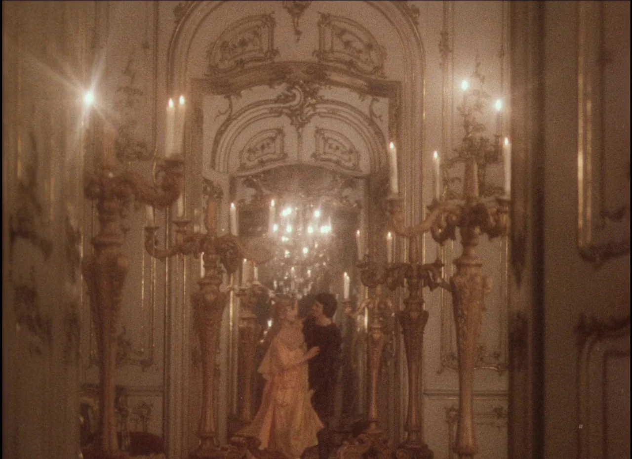 Beauty and the Beast (1979) movie still: medium — An opulent mirrored hallway features intricate gold trim, ornate moldings, and tall candle-bearing…