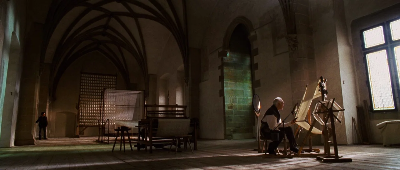 Wanted (2008) movie still: wide — A spacious stone chamber features vaulted ceilings, arched windows, and traditional textile weaving equipment. An…