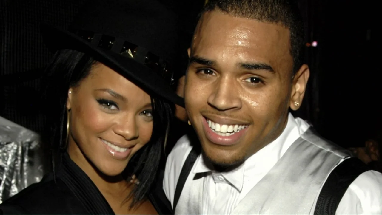 Chris Brown: A History of Violence (2024) movie still: closeup — Two individuals stand closely together against a dark, indistinct backdrop. They…