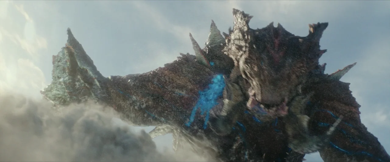 Pacific Rim: Uprising (2018) movie still: medium — A massive, scaled beast covered in sharp spikes towers above a thick cloud bank. The creature…