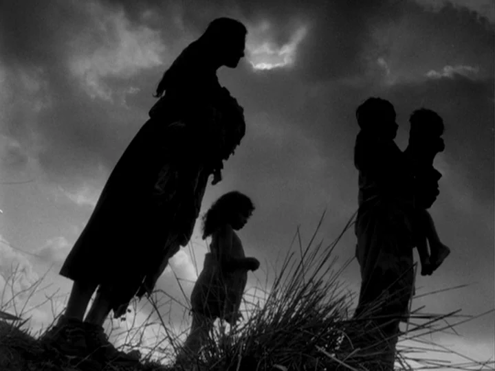 I Am Cuba (1964) movie still: fullbody — An open grassy field under a cloudy, overcast sky during the daytime. A group of three people are…