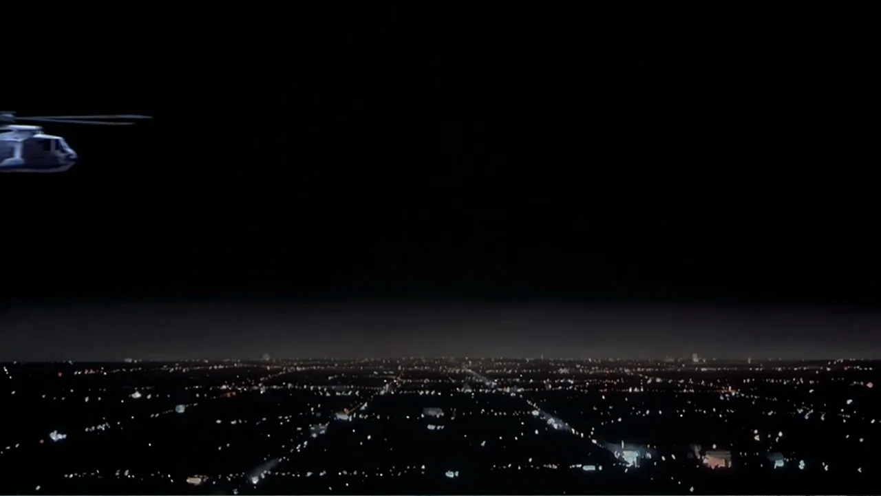 Naked Gun 33⅓: The Final Insult (1994) movie still: wide — A dark night sky hangs over a sprawling illuminated grid of a city. A small helicopter…