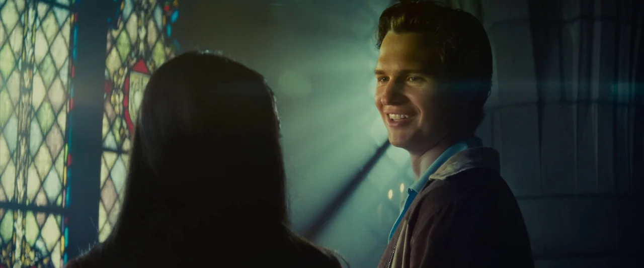 Making of: West Side Story (2021) movie still: medium — A man stands in front of a stained glass window inside a church interior. He looks down at a…