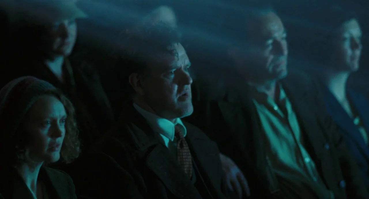 Jimmy’s Hall (2014) movie still: medium — A dimly lit movie theater filled with spectators sitting in dark rows. The light from a projector reflects…