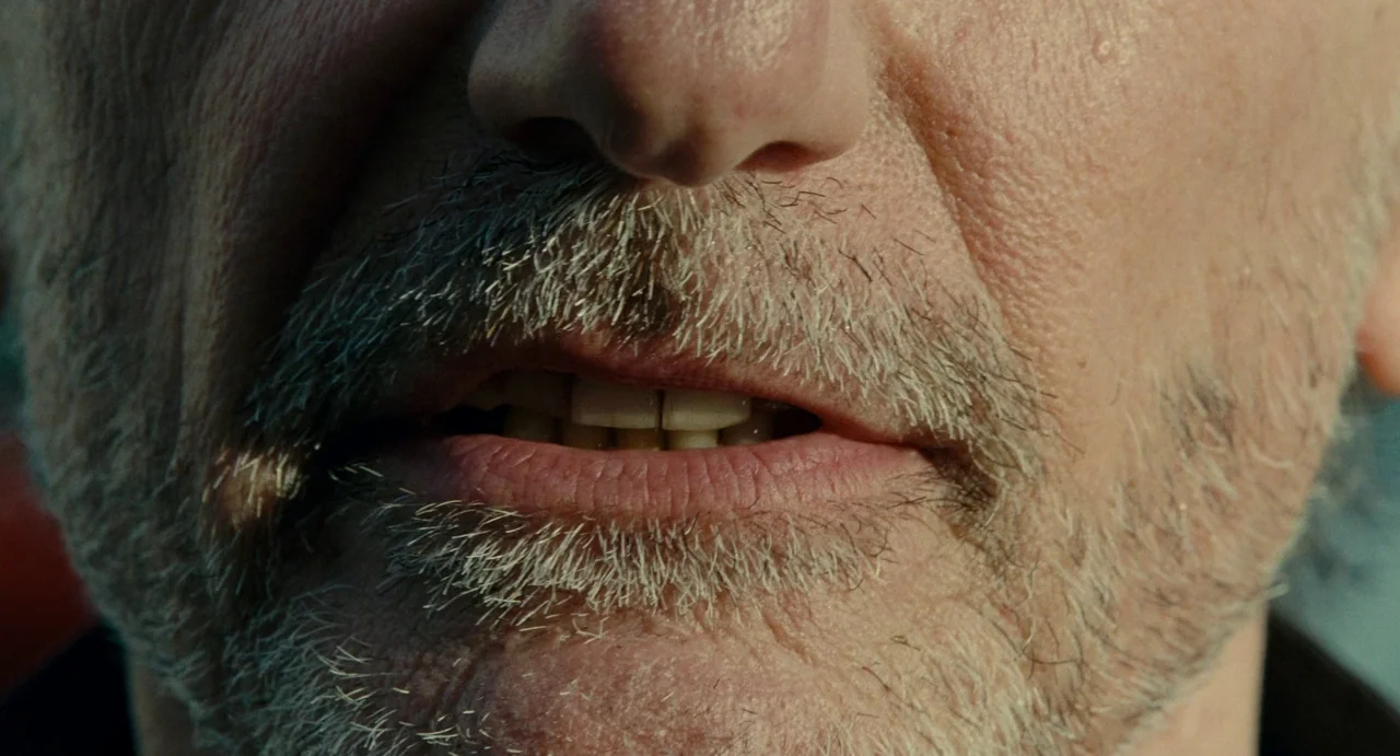 Young & Beautiful (2013) movie still: closeup — A close-up view focuses on the nose, mouth, and chin of an older man. The man has a short grey beard…