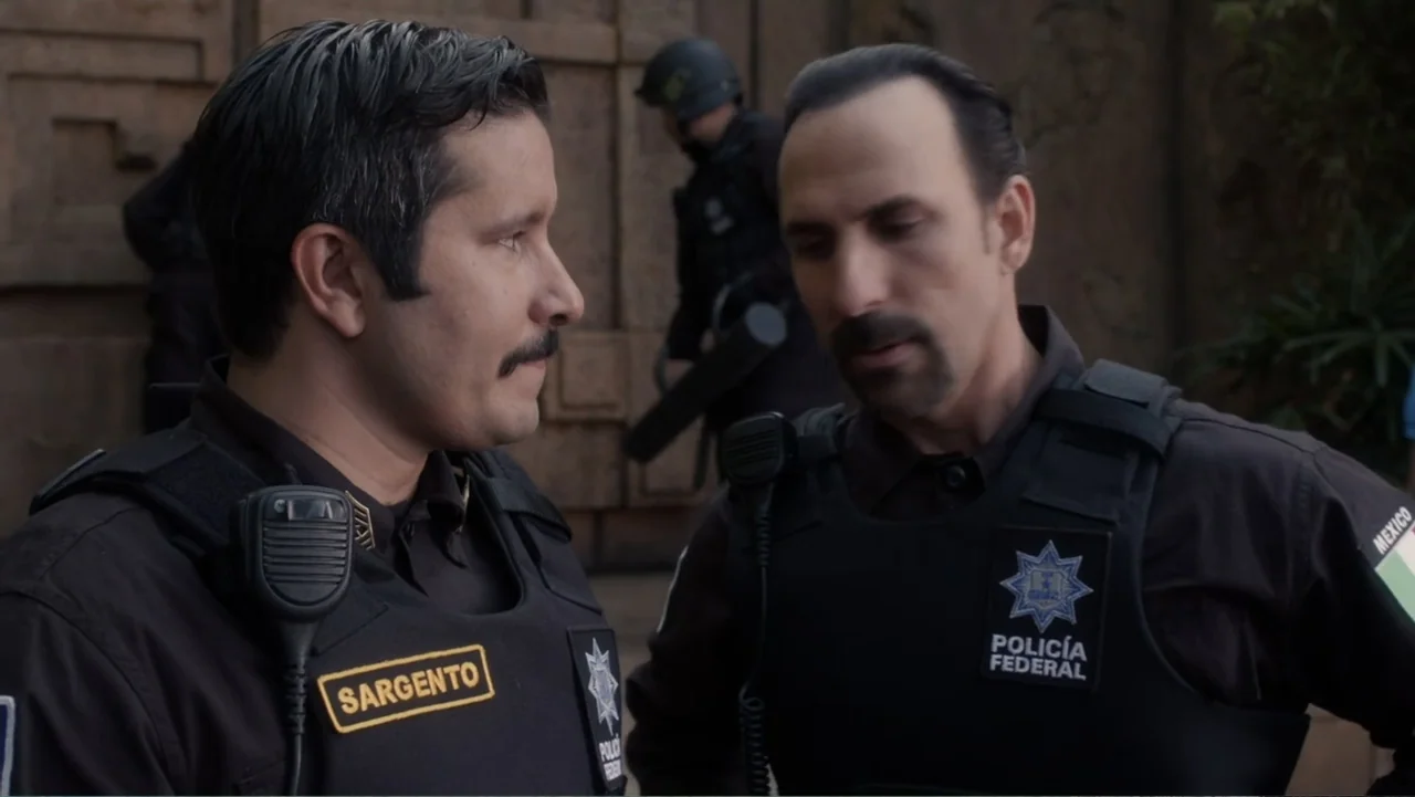 Legends of the Hidden Temple (2016) movie still: medium — Two Mexican federal police officers stand in an urban environment wearing tactical…