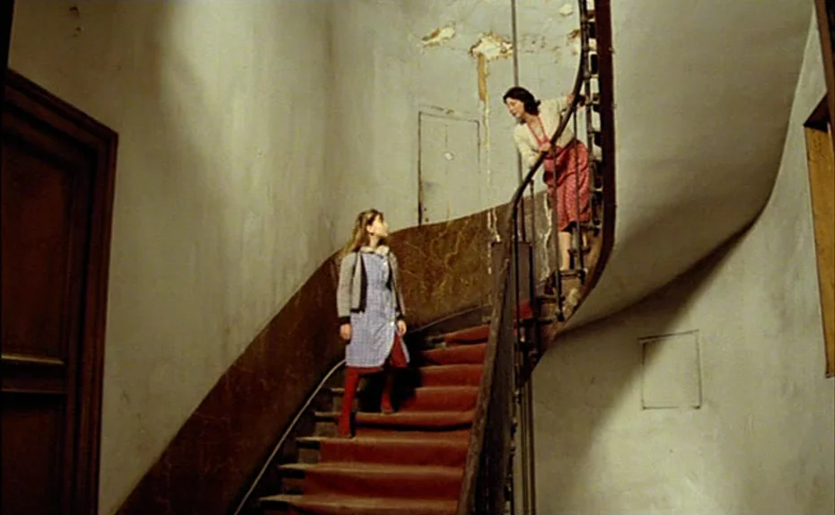 My American Uncle (Mon oncle d’Amérique) (1980) movie still: wide — A curved indoor staircase features peeling wall plaster and a dark metal…