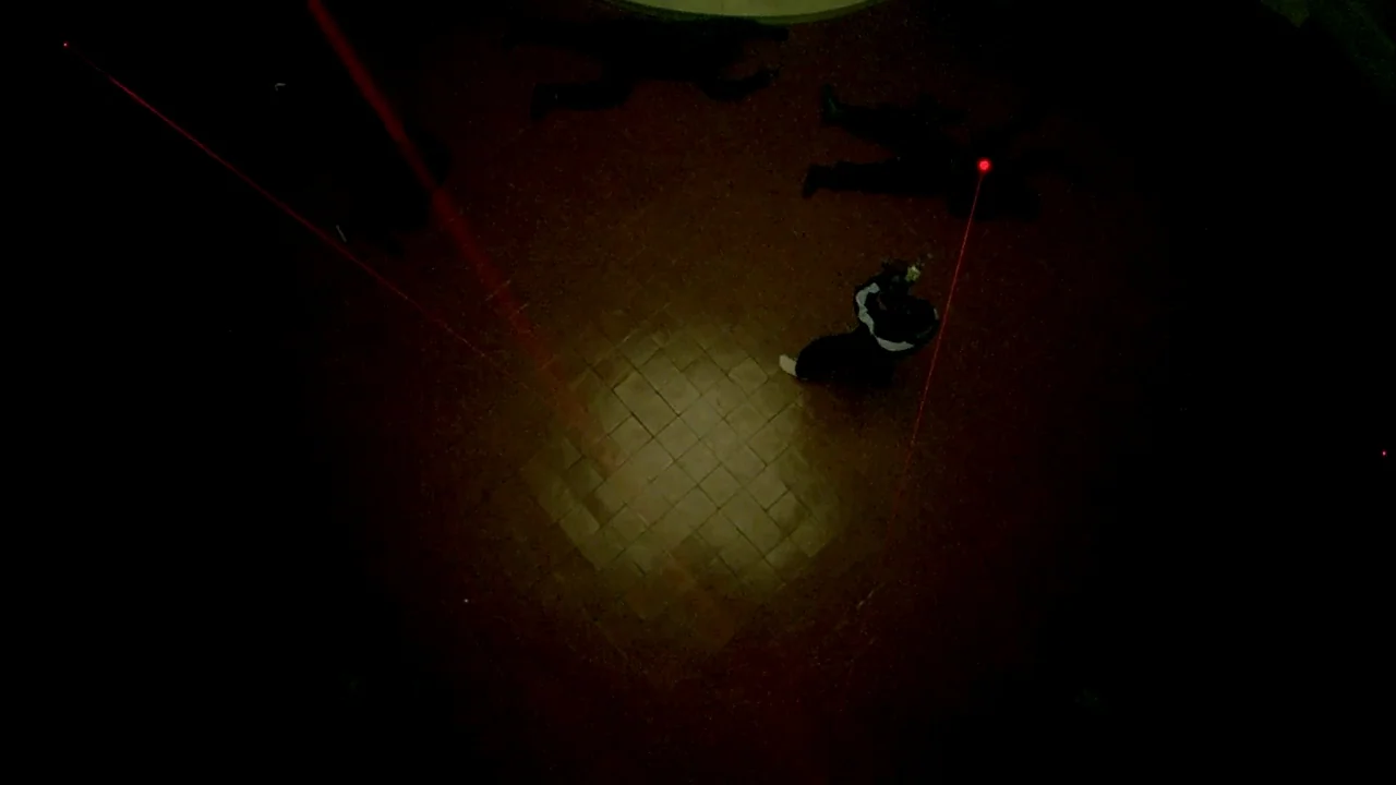 Belly (1998) movie still: wide — A dark, empty space with a tiled floor lit by a singular focused light. One person stands central surrounded by…