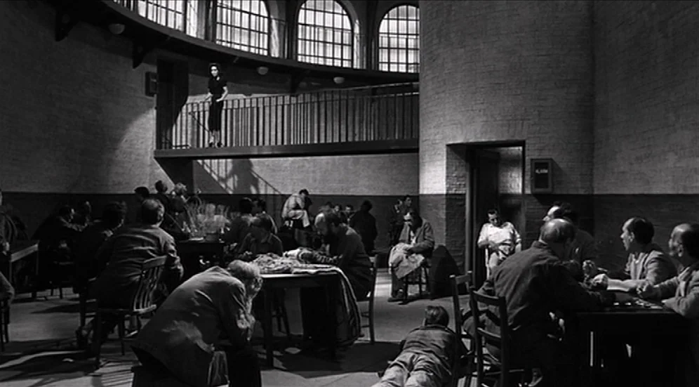 Suddenly, Last Summer (1959) movie still: wide — A circular room with high arched windows and a mezzanine balcony level. Numerous men occupy tables…