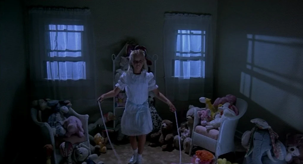 A Nightmare On Elm Street 2: Freddy’s Revenge (1985) movie still: fullbody — A dimly lit room is filled with numerous stuffed animals clustered on…