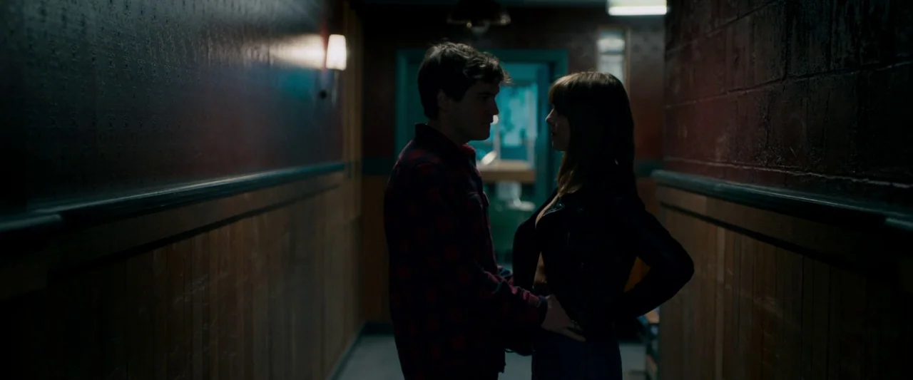 The Autopsy of Jane Doe (2016) movie still: medium — A dimly lit narrow corridor features wood-paneled walls and exposed brick segments. A man and a…