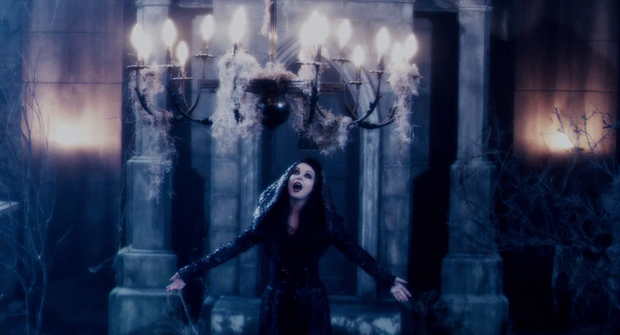 Repo! The Genetic Opera (2008) movie still: fullbody — A stone mausoleum is adorned with draped cobwebs and flickering light sources. A woman stands…