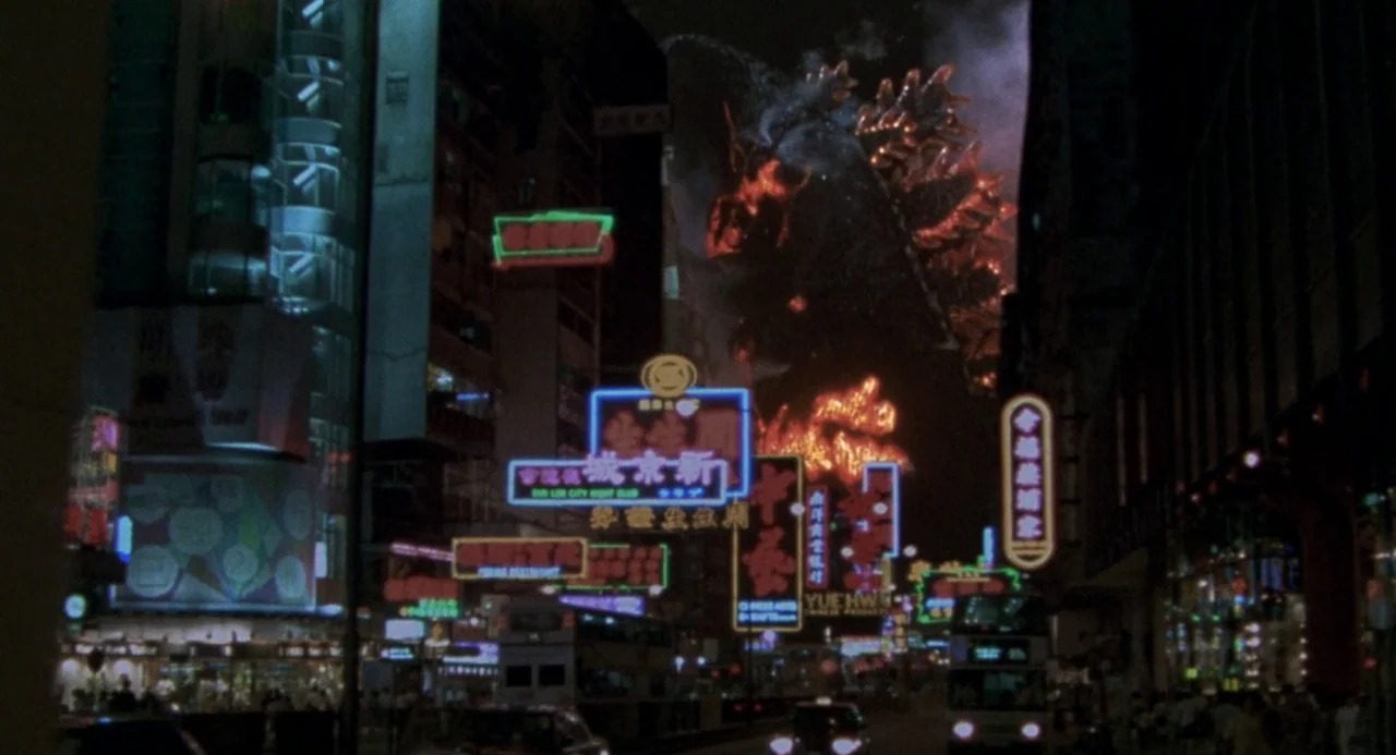 Godzilla vs. Destoroyah (1995) movie still: wide — A dense urban night scene features multi-story buildings covered in bright, glowing neon signage.…