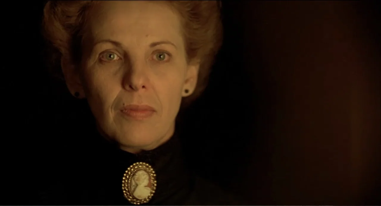 Like Water for Chocolate (1992) movie still: closeup — A dark, minimally furnished interior space serves as the setting for a portrait. An elderly…