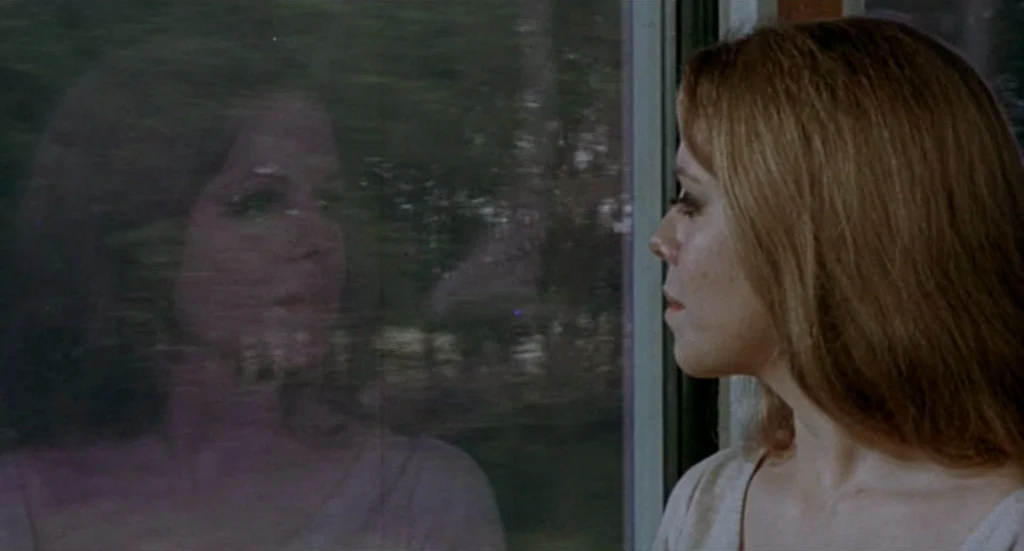 Fahrenheit 451 (1966) movie still: medium — A woman sits inside a train carriage looking at the moving landscape outside. Her face is partially…