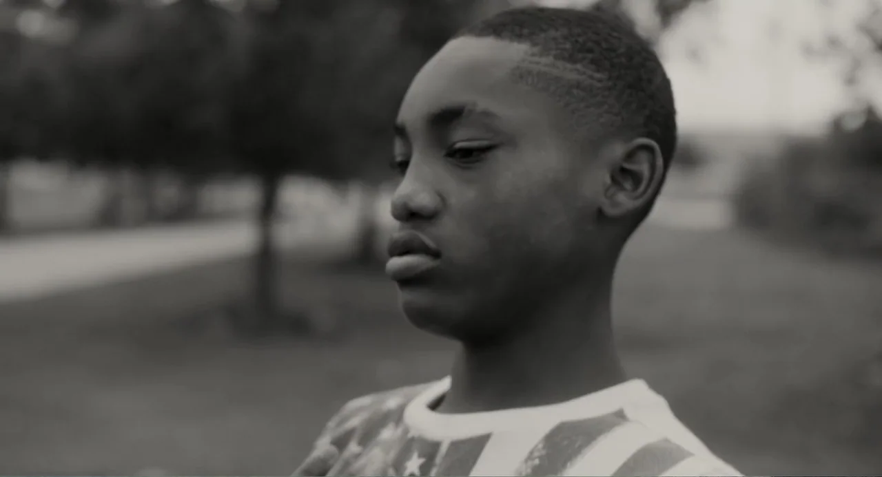 What You Gonna Do When the World's on Fire? (2019) movie still: closeup — A park with blurred trees and greenery fills the background in a soft…