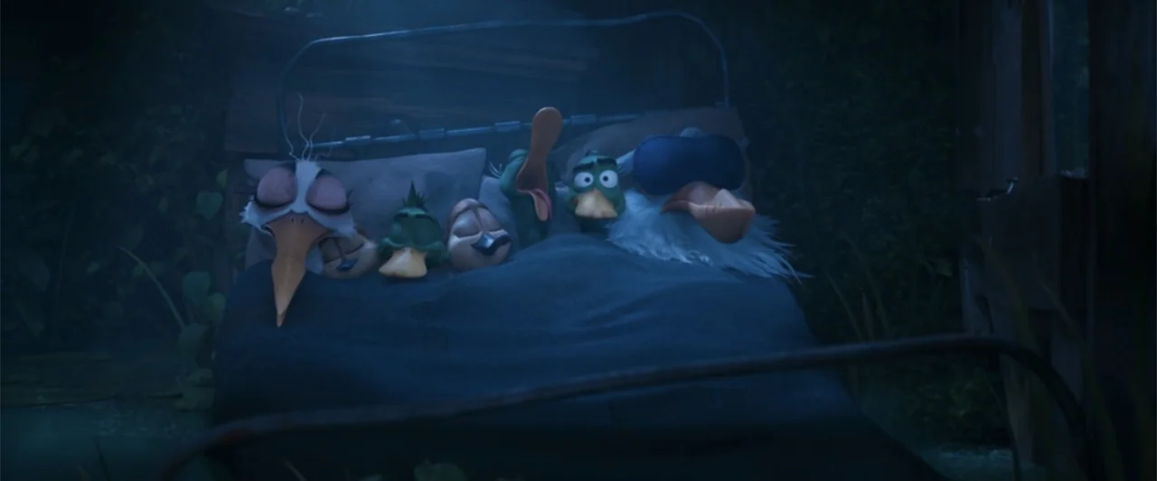 Migration (2023) movie still: medium — A dark bedroom contains a bed where multiple cartoon birds are sleeping together under blankets. Several…