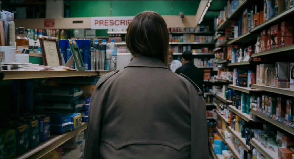 Eastern Promises (2007) movie still: medium — A pharmacy aisle features long shelves stocked with various colorful consumer goods and toiletries. A…