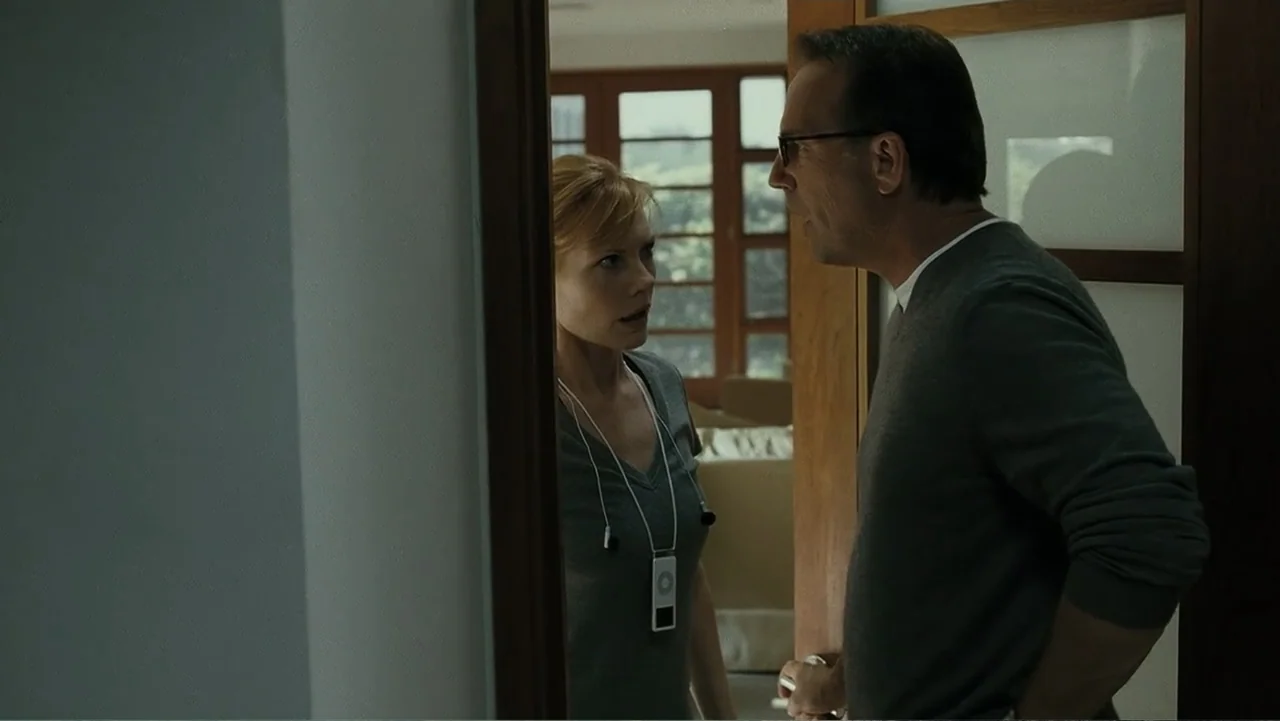 Mr. Brooks (2007) movie still: medium — A man and woman stand in the threshold of a brightly lit room. They face each other while engaged in a…