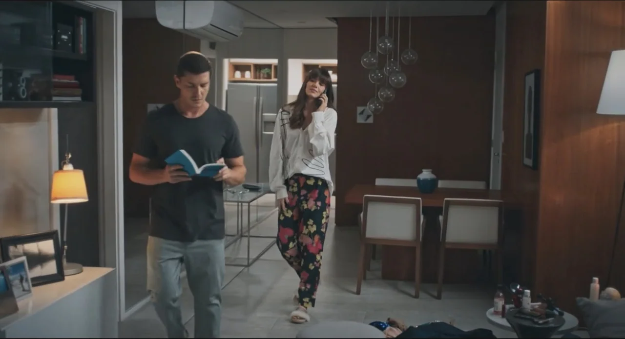 Proof of Love (2022) movie still: fullbody — A modern, open-plan apartment features wood-paneled walls and contemporary furniture pieces. A man…