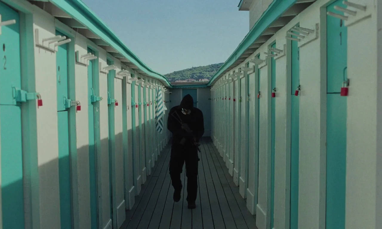Vox Lux (2018) movie still: fullbody — Rows of turquoise and white wooden lockers align perfectly along a narrow wooden walkway. A lone individual…