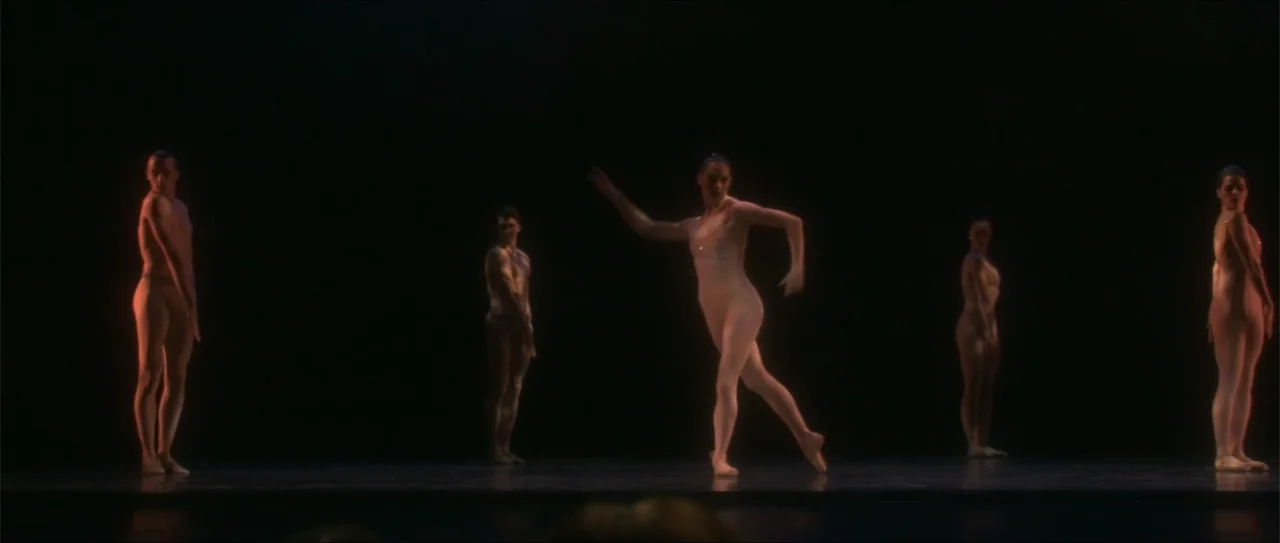 El acto (1989) movie still: wide — A dark stage illuminated only by spotlights highlighting the dancers. Five performers in leotards execute…