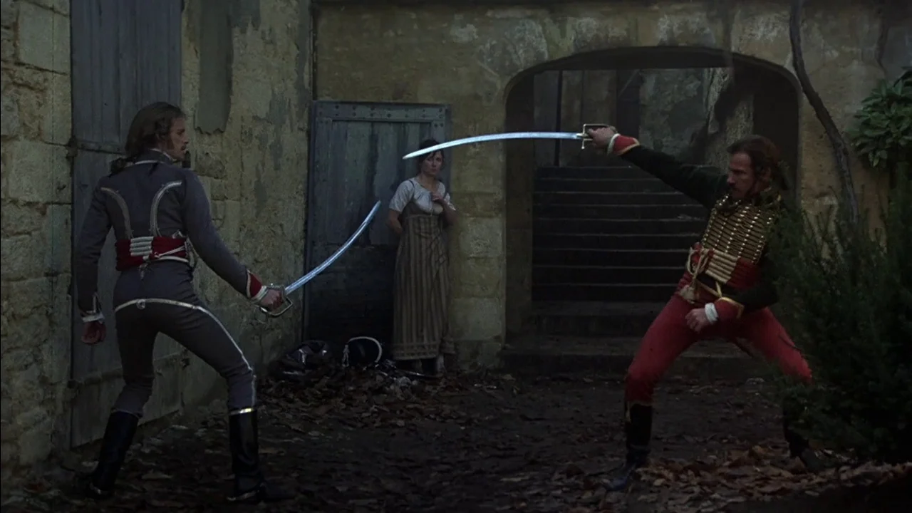 The Duellists (1977) movie still: fullbody — An ancient stone courtyard with a dark doorway and a set of stairs. Two men in period military uniforms…