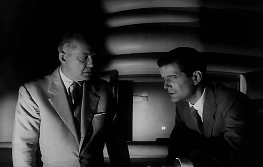 Caltiki, The Immortal Monster (1959) movie still: medium — An interior space features curved, layered architectural elements behind two men in…