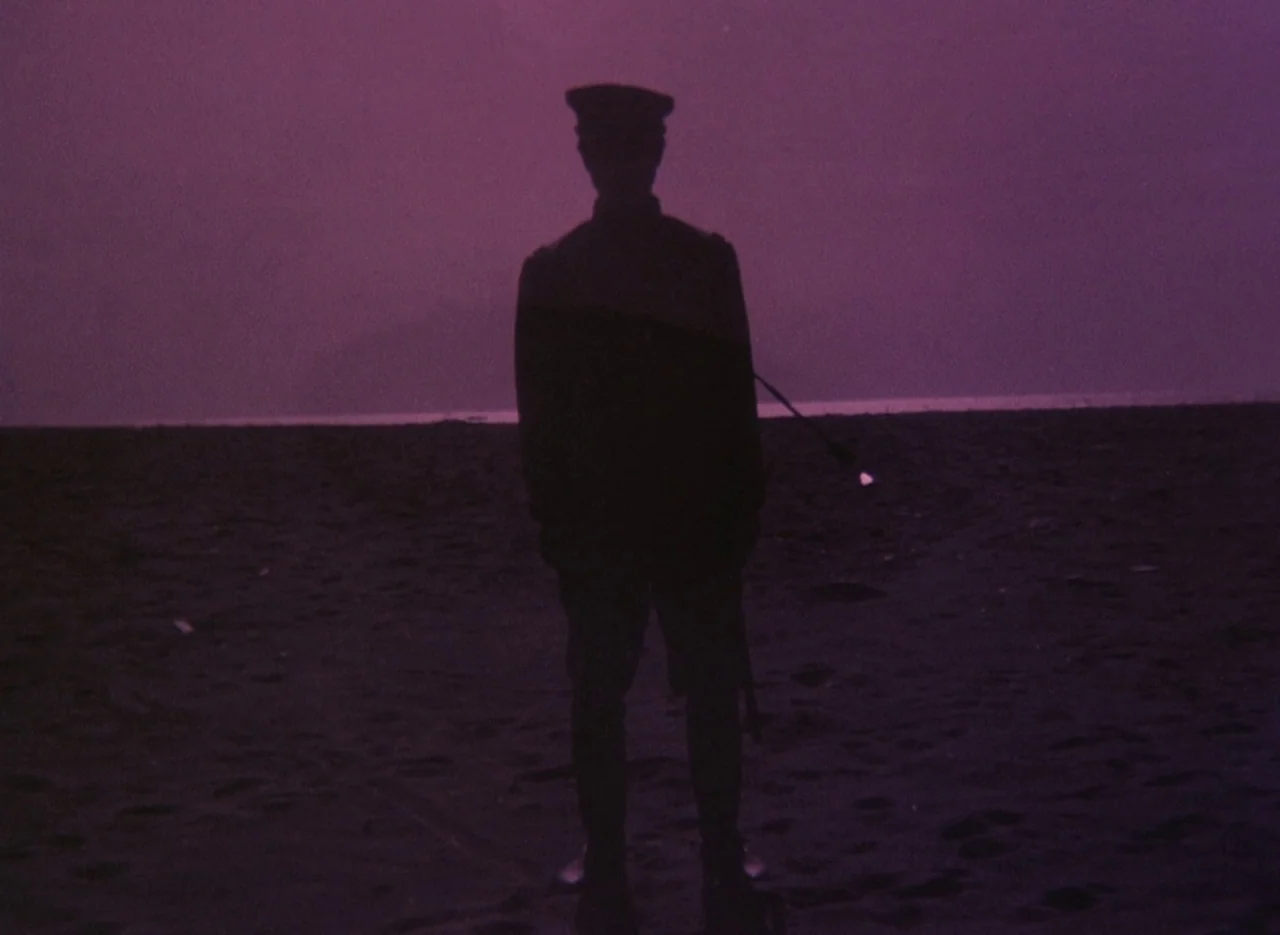 Pastoral To Die In The Country (1974) movie still: fullbody — A dark, empty beach stretches out beneath a purple sky at night. A lone soldier stands…
