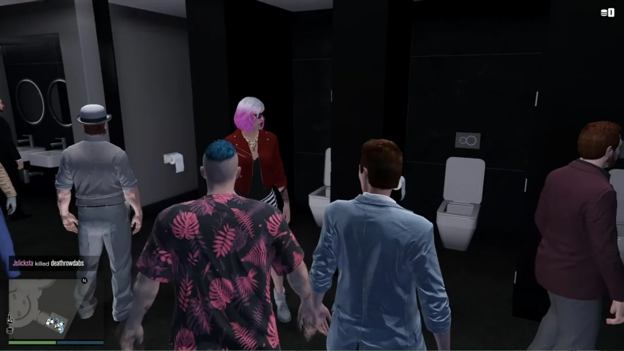 Grand Theft Hamlet (2024) movie still: medium — A modern, minimalist public restroom features black walls and stark white ceramic fixtures. Several…