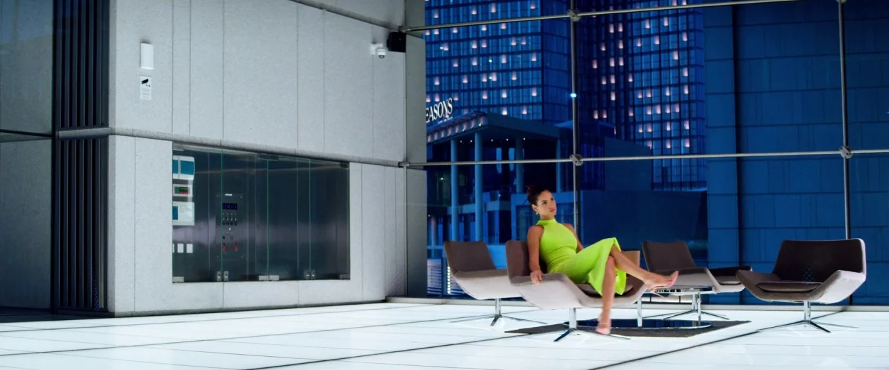 6 Underground (2019) movie still: wide — A modern, minimalist building interior with high-gloss white floor tiles and floor-to-ceiling glass. A…
