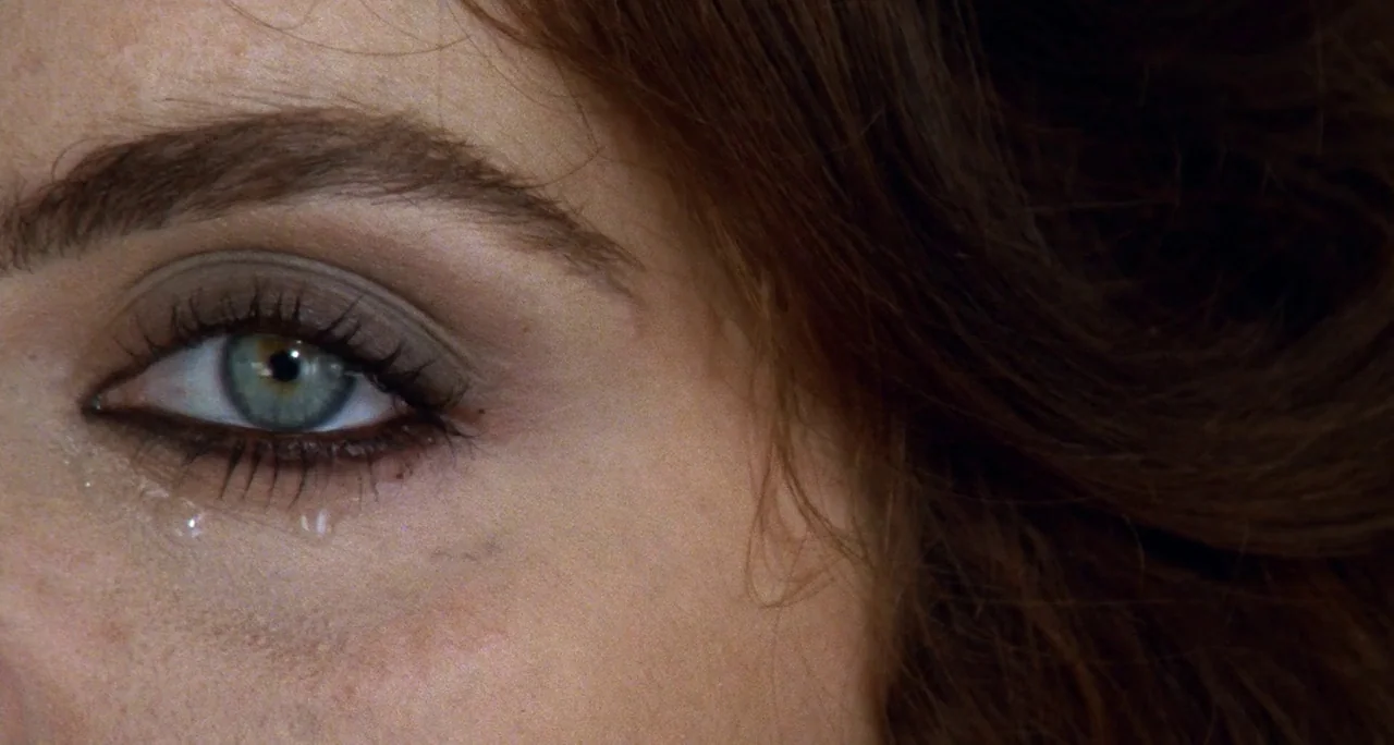 Tenebre (1982) movie still: closeup — An extreme close-up view focuses on a human eye and surrounding facial features. A single tear rests on the…