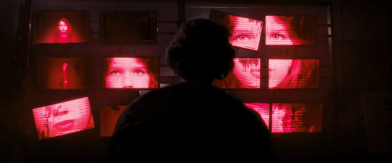Resident Evil: The Final Chapter (2016) movie still: medium — A dimly lit room features a large metal rack holding numerous glowing red monitors. A…