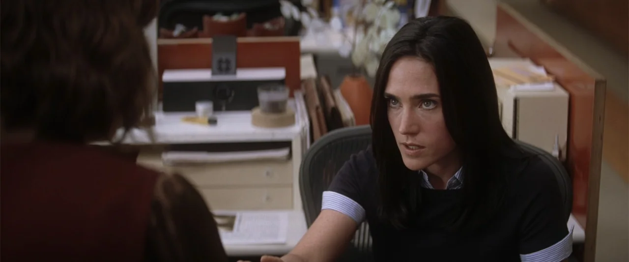He's Just Not That Into You (2009) movie still: medium — A cluttered professional work desk with papers and office supplies sits in the background.…