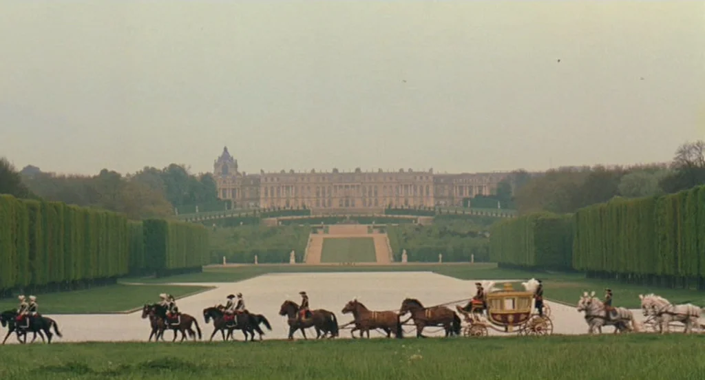 Marie Antoinette (2006) movie still: establishing — The expansive, symmetrical grounds of a grand palace feature manicured hedges and wide gravel…