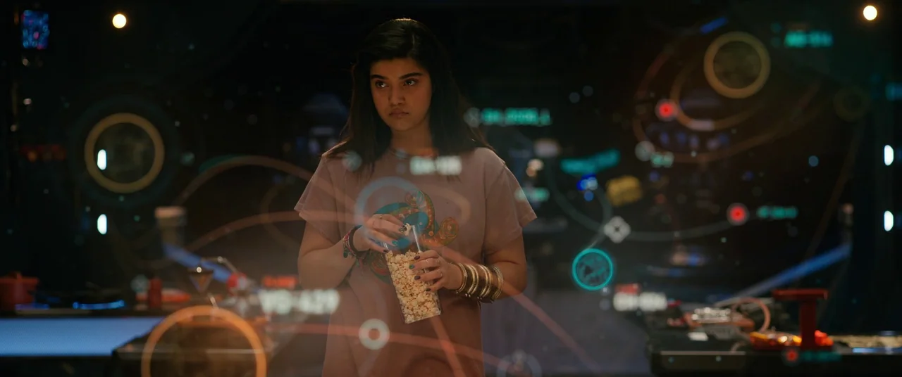 The Marvels (2023) movie still: medium — A dimly lit high-tech environment displays complex glowing holographic data maps around a woman. She stands…