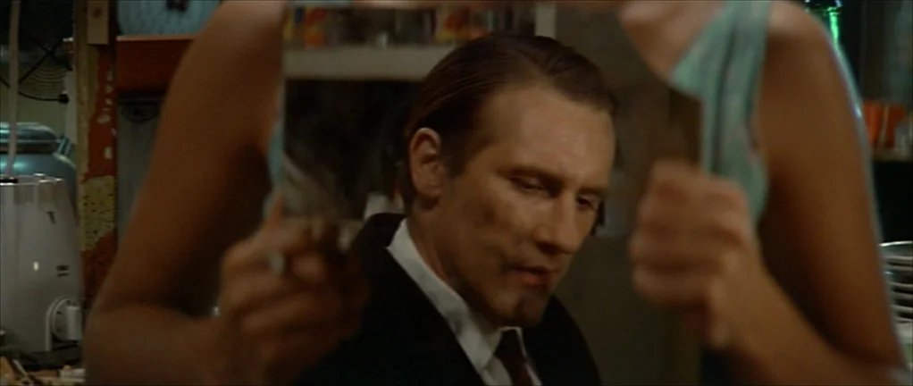 The Moon in the Gutter (1983) movie still: medium — A dimly lit indoor space featuring a cluttered domestic environment with kitchen appliances…