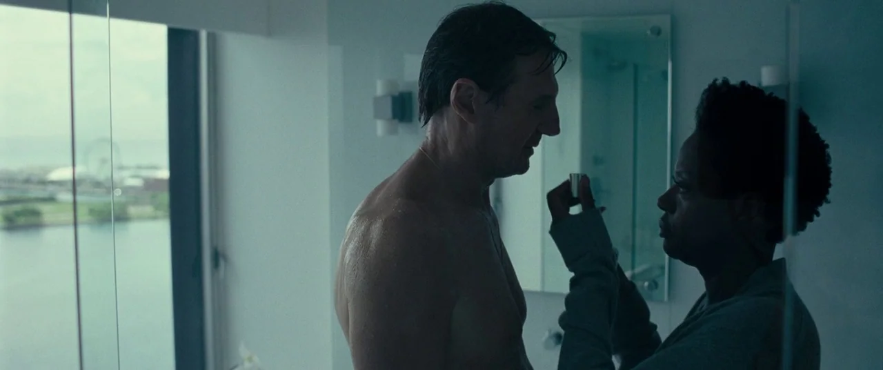 Widows (2018) movie still: medium — A modern bathroom features a floor-to-ceiling window overlooking a distant waterfront city skyline. A man and a…