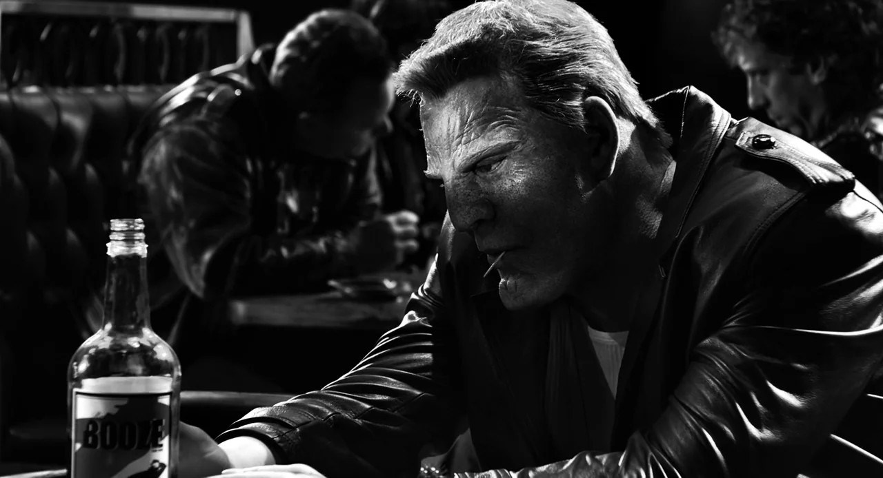 Sin City: A Dame to Kill For (2014) movie still: medium — A dark, high-contrast bar setting with leather-backed seating visible in the background. A…