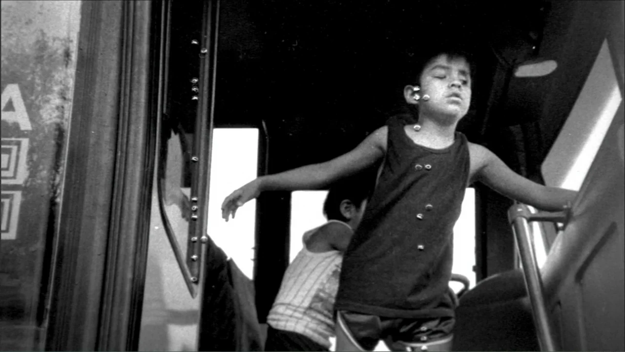 Dark Light: The Art of Blind Photographers (2009) movie still: medium — The interior of a bus with metal door frames and bright windows in daylight.…
