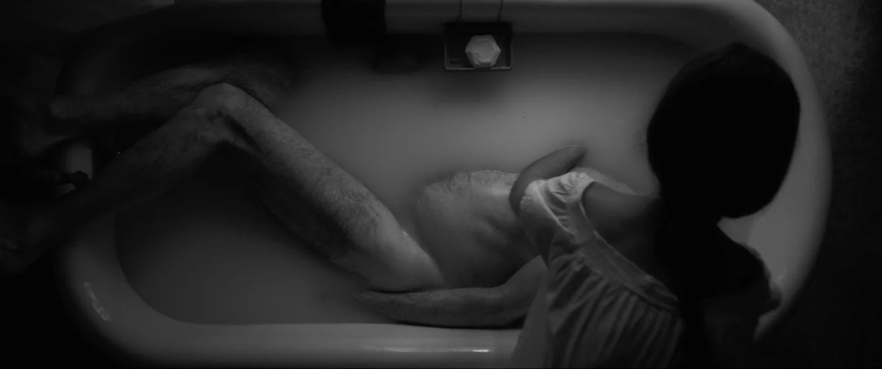 The Eyes of My Mother (2016) movie still: wide — A top-down view shows a white bathtub filled with opaque, milky liquid. An emaciated man is…