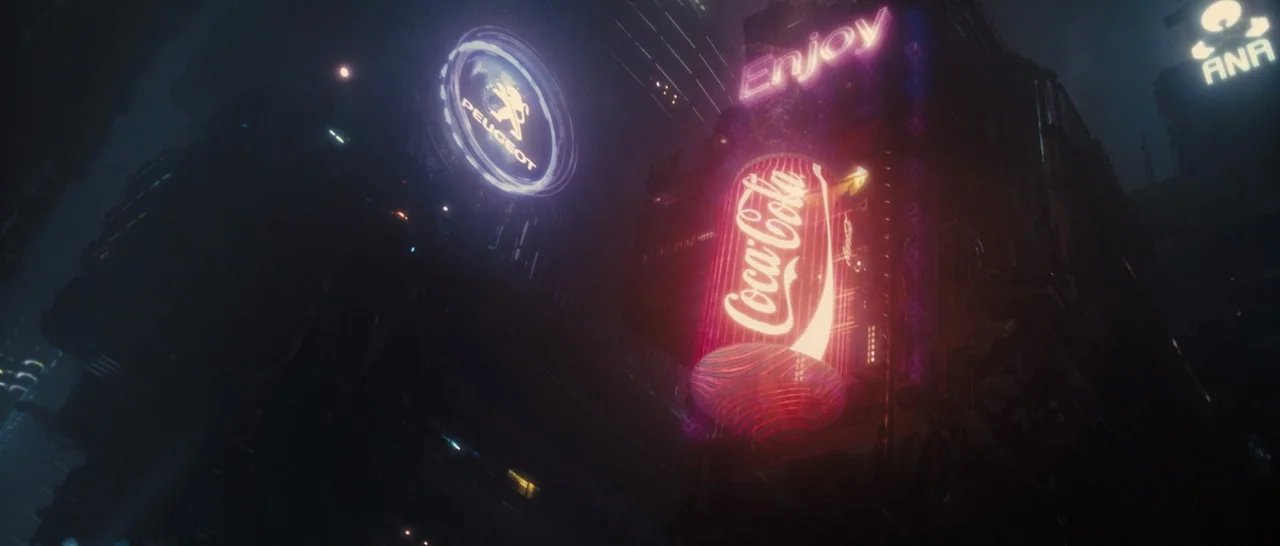 Blade Runner 2049 (2017) movie still: establishing — A dark, dense urban canyon is dominated by glowing neon advertisements for global corporations.…