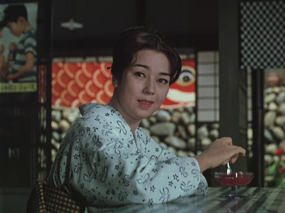 Floating Weeds (1959) movie still: medium — A Japanese restaurant features decorative koinobori carp streamers in the background and stone walls. A…