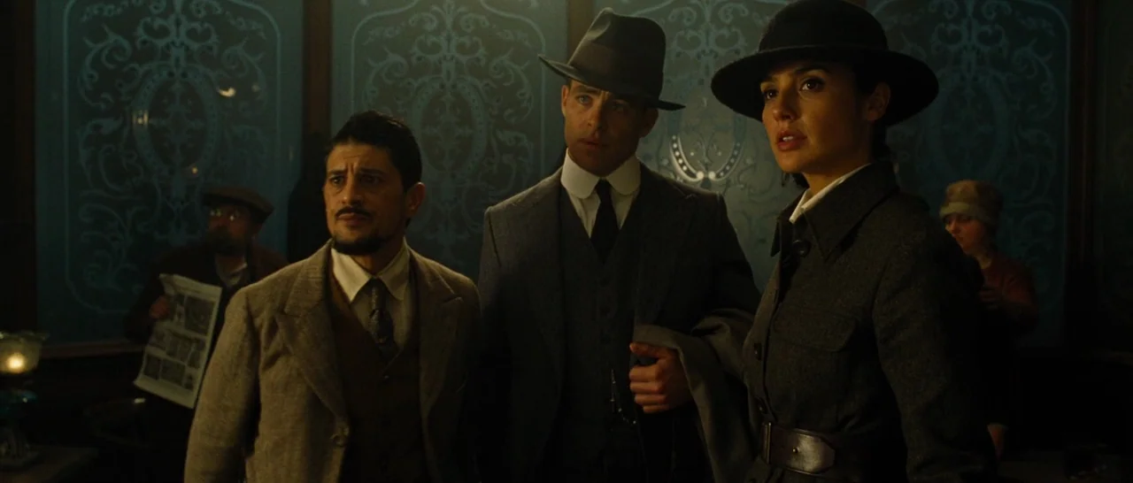 Wonder Woman (2017) movie still: medium — A dimly lit indoor space featuring intricate blue damask wallpaper and period-appropriate decor. Three…