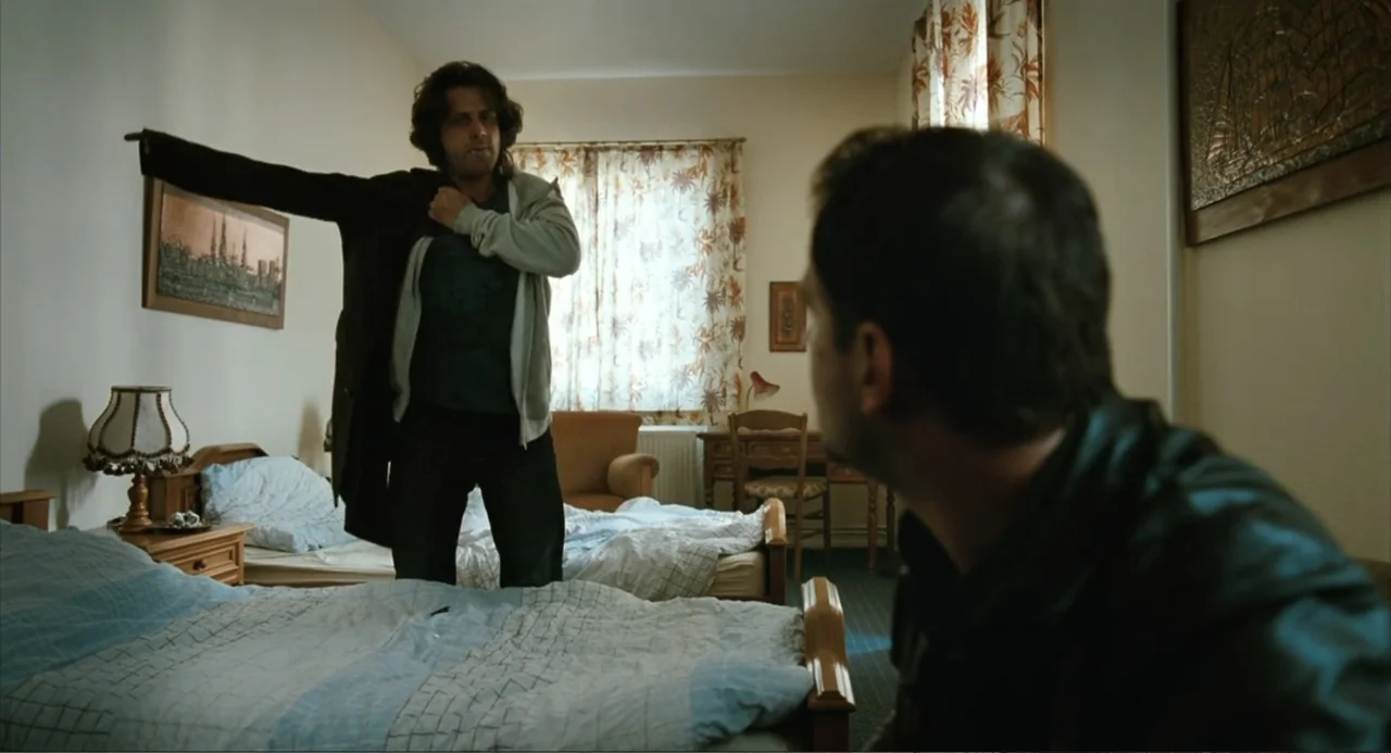Soul Kitchen (2009) movie still: medium — A dated motel room features two beds with plaid covers and floral curtains.
